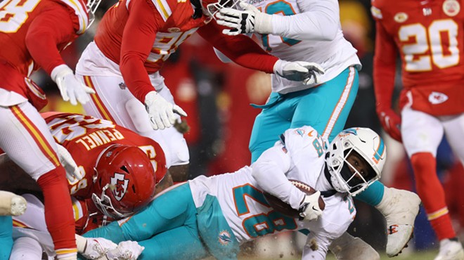 Miami Dolphins running back De'Von Achane is pulled to the frozen ground in an NFL playoff game against the Kansas City Chiefs